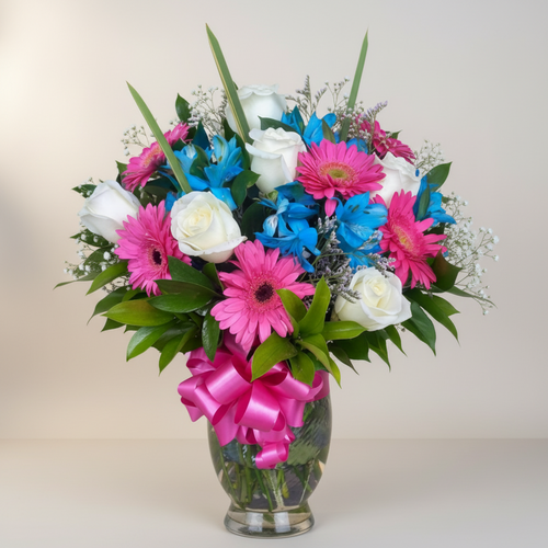 Arreglo floral en jarrón de cristal con flores rosas, azules y blancas Ramo de flores en jarrón de cristal con rosas blancas, gerberas rosas, flores azules y lazo rosa brillante