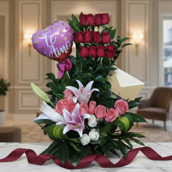 Arreglo floral exótico primaveral con lirios blancos, rosas rosadas y rojas, follaje verde, sobre mármol pulido con cinta dec