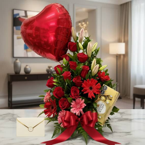 Arreglo floral "Te Amo" con rosas rojas, liliums blancos, gerberas rosadas y rojas, follaje verde, globo de corazón rojo, cho