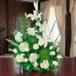 Arreglo fúnebre Adiós Para Siempre con lirios, hortensias y rosas blancas, en una sala de velación premium con luz natural y