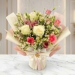 Bouquet Floral SUSANA con rosas blancas y rosadas, astromelias y follaje verde, envuelto en papel coreano rosa y crema, sobre