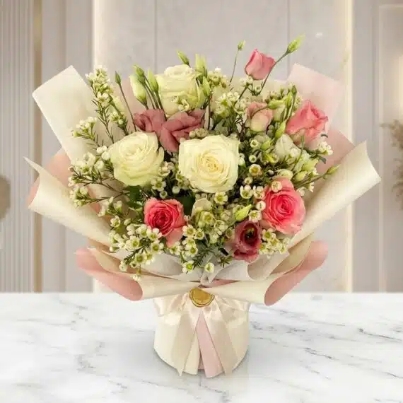 Bouquet Floral SUSANA: Rosas y Astromelias en Empaque Coreano Elegante Bouquet Floral SUSANA con rosas blancas y rosadas, astromelias y follaje verde, envuelto en papel coreano rosa y crema, sobre
