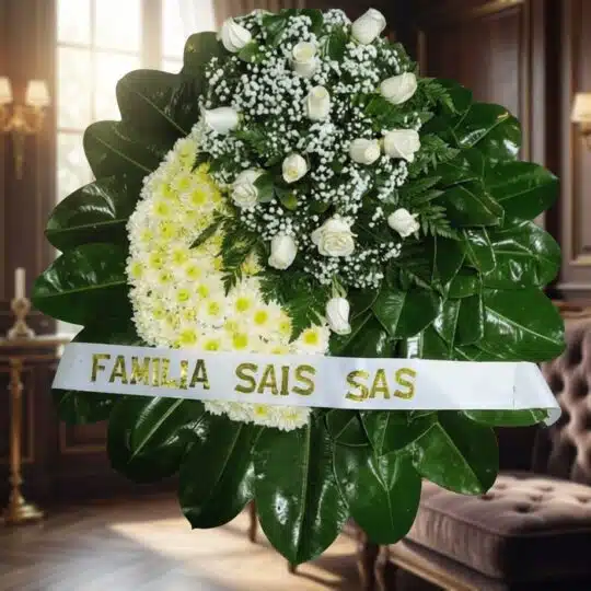 Corona fúnebre Descansa en Paz con rosas blancas y crisantemos amarillos, cinta personalizada, en sala de velación premium co