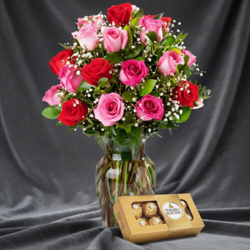 Jarrón Te Extraño con un hermoso arreglo de rosas rojas y rosadas, complementado con follaje verde y pequeñas flores blancas,